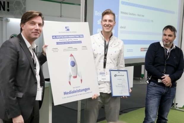Uwe Berger, Präsident des Marketing Clubs Hannover und Dr. Florian Heinemann, Project A, übergeben Janik Lipke, parcelLab den Scheck